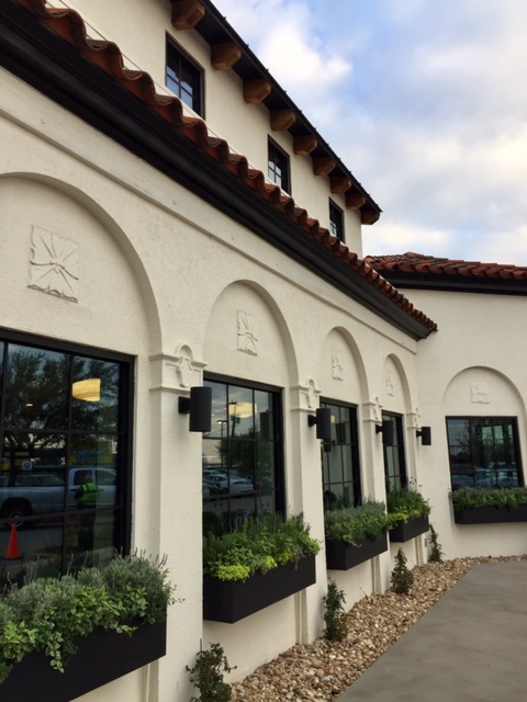 Magnolia Table restaurant exterior with black window boxes full of greenery. #magnoliatable #fixerupper #restaurant #waco