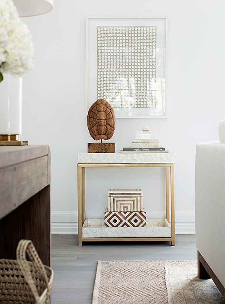 Gold toned bar cart is covered in capiz—for texture in a Chantilly Lace painted bright white space.