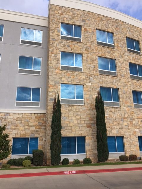 Facade of Hotel Indigo Waco-Baylor with Stone & Blue Windows #hotelindigo