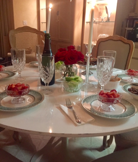 Saarinen table set with green, white, and red tablescape elements in a Paris inspired dining room by Hello Lovely Studio.
