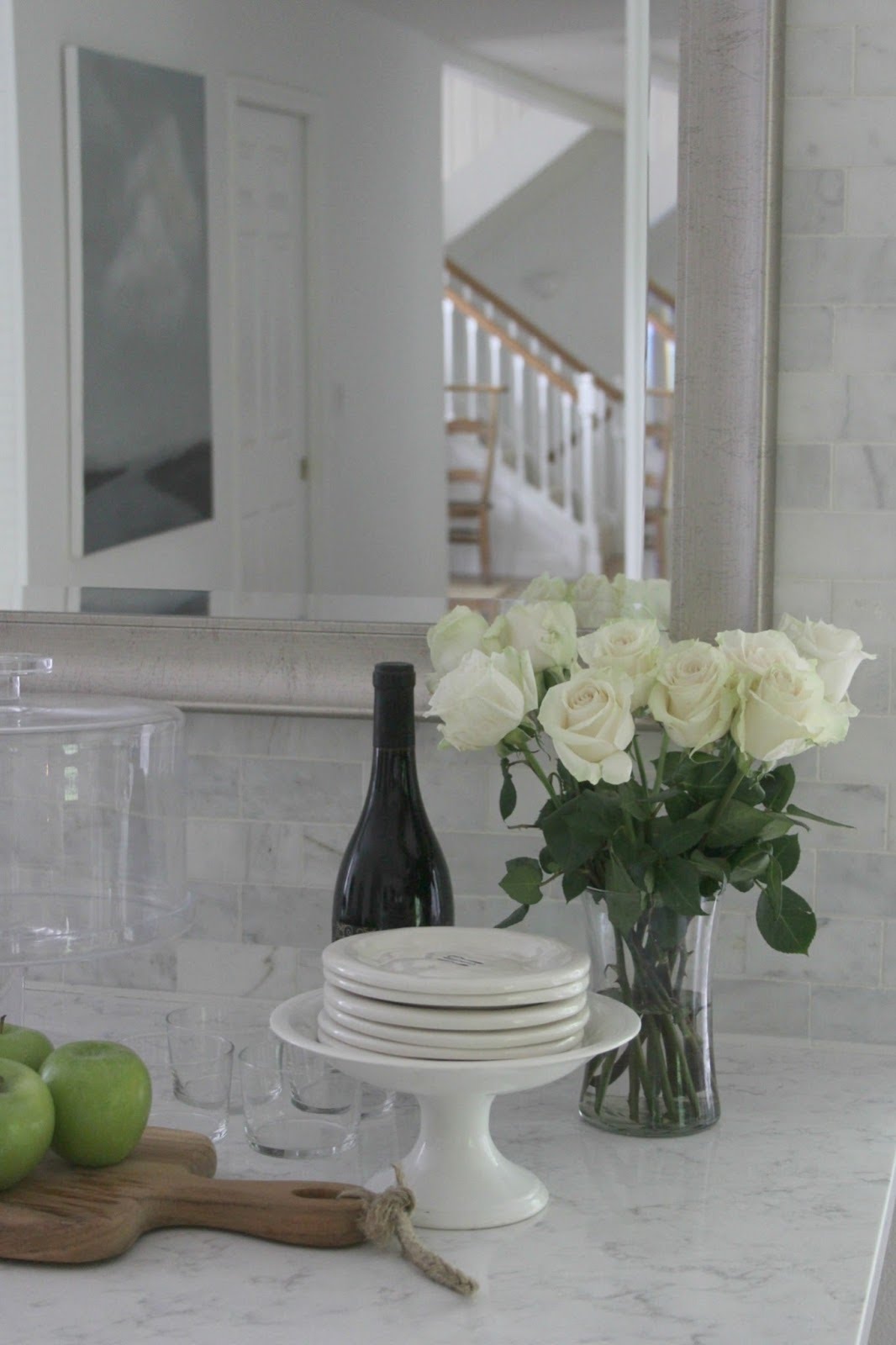 Serene white kitchen decor with Viatera Minuet countertop, marble subway tiles, white roses, and silver framed mirror. #whitekitchen #whitedecor #kitchendecor #subwaytile #quartz #whiteroses #hellolovelystudio #timelessdesign #serene 