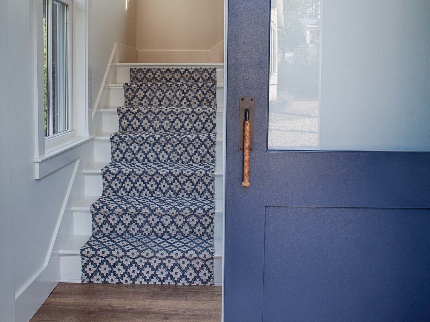 Blue stair runner and door. Board and batten coastal cottage in Palmetto Bluff with modern farmhouse interior design by Lisa Furey.