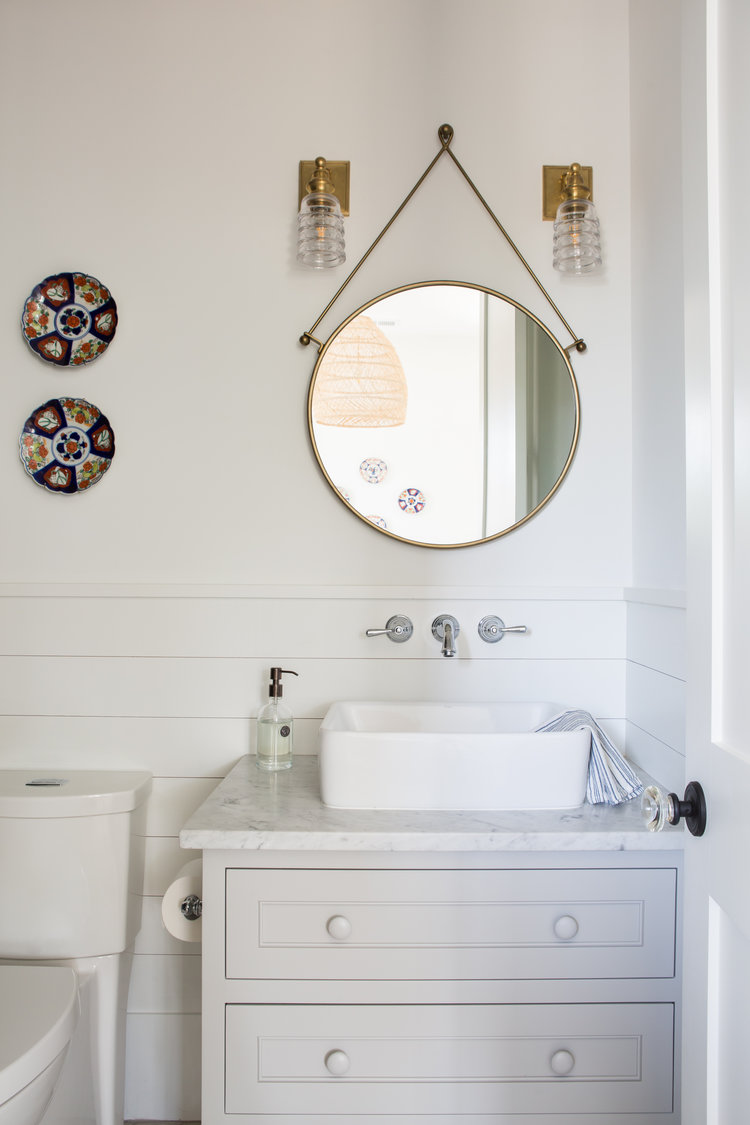 Coastal bathroom with vessel sink, shiplap, and round mirror. Board and batten coastal cottage in Palmetto Bluff with modern farmhouse interior design by Lisa Furey.