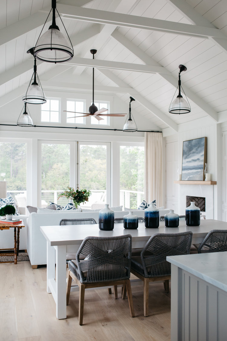 Coastal breezy style in a dining area open to a great room with ship in a board and batten coastal cottage. Interior design by Lisa Furey. #greatroom #shiplap #coastalstyle #coastalcottage #interiordesign