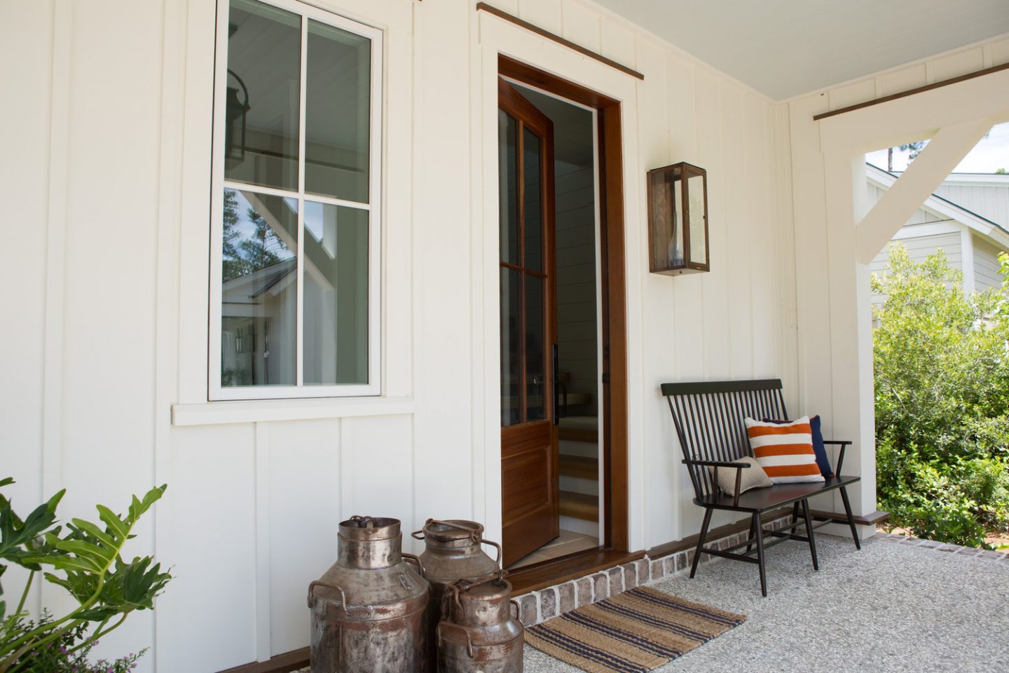 Front porch with farmhouse decor. Board and batten coastal cottage in Palmetto Bluff with modern farmhouse interior design by Lisa Furey.