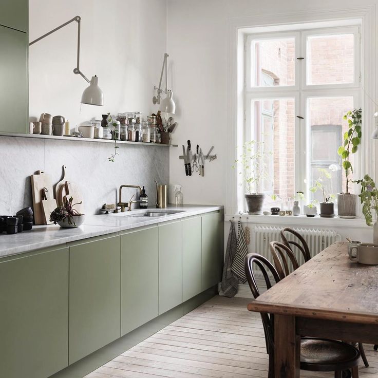 Serene and stylish Scandinavian kitchen with mossy green cabinets and modern adjustable arm sconces - Petra Bindel. #swedishkitchen #scandinaviandesign #nordicstyle #europeancountry #kitchendesign