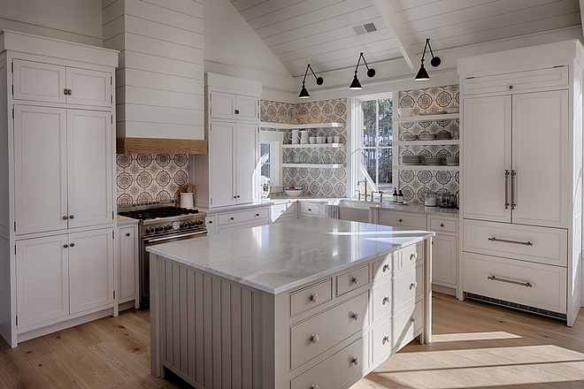 White coastal kitchen with modern farmhouse and Shaker designer elements. Island is painted Sherwin Williams Tinsmith. Lisa Furey created a welcoming home with shiplap, nods to coastal design, and blue accents. #coastalkitchen #modernfarmhousekitchen #kitchendesign #shiplap #shakerkitchen
