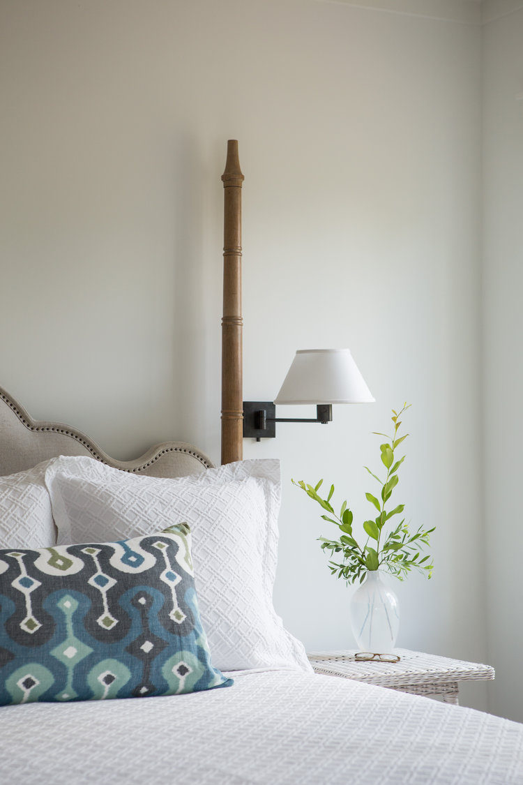 Coastal blues on a batik pillow in a coastal bedroom painted Benjamin Moore White OC-151 (Lisa Furey). #benjaminmoorewhite #whitepaintcolors