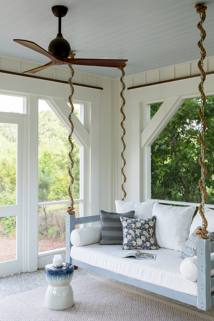 Blue painted porch ceiling and porch swing. Board and batten coastal cottage in Palmetto Bluff with modern farmhouse interior design by Lisa Furey. Come peek at Charming Porch Inspiration & Decor Ideas.