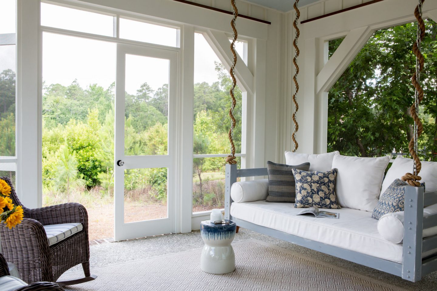 Porch swing. Board and batten coastal cottage in Palmetto Bluff with modern farmhouse interior design by Lisa Furey.