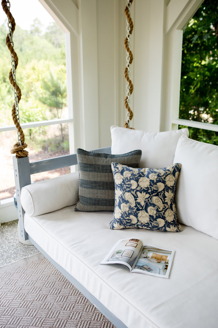 Porch swing. Board and batten coastal cottage in Palmetto Bluff with modern farmhouse interior design by Lisa Furey.