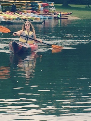 Teen girl in lifejacket kayaking. Hello Lovely Studio.