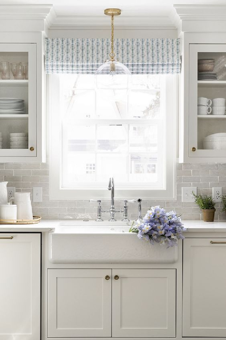 Soft white kitchen with white terracotta subway tile backsplash white quartz countertop and white farmhouse sink. Come see 36 Best Beautiful Blue and White Kitchens to Love! #blueandwhite #bluekitchen #kitchendesign #kitchendecor #decorinspiration #beautifulkitchen