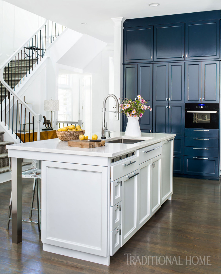 A 12-foot-tall wall of blue cabinetry echoes the backsplash color and allows a black Thermador steam oven to almost disappear. Come see 36 Best Beautiful Blue and White Kitchens to Love! #blueandwhite #bluekitchen #kitchendesign #kitchendecor #decorinspiration #beautifulkitchen