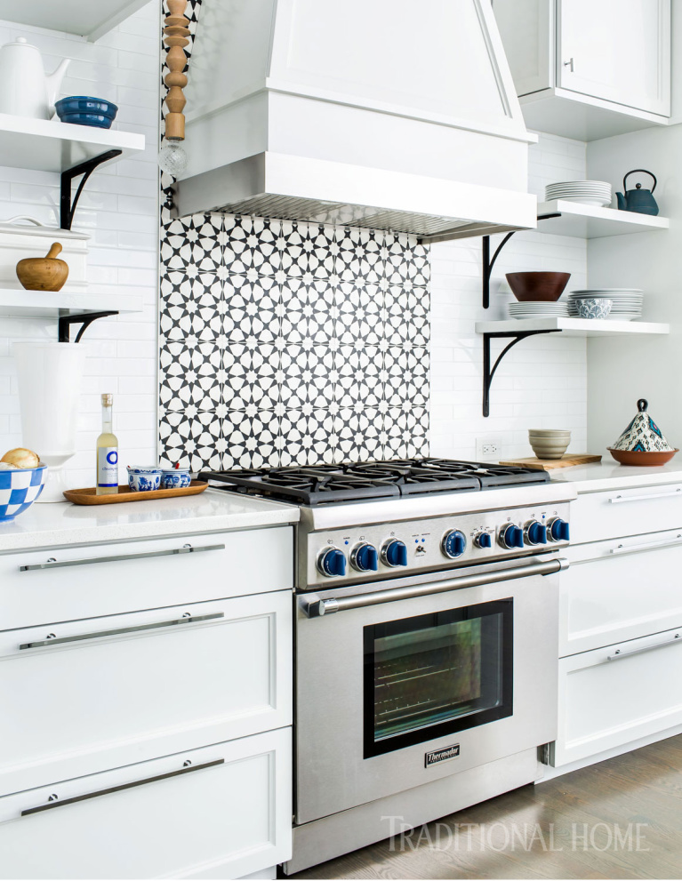 The custom vent hood above the Thermador range is mostly wood with a band of stainless steel closest to the heat. The patterned concrete backsplash tiles have color that goes all the way through. Come see 36 Best Beautiful Blue and White Kitchens to Love! #blueandwhite #bluekitchen #kitchendesign #kitchendecor #decorinspiration #beautifulkitchen