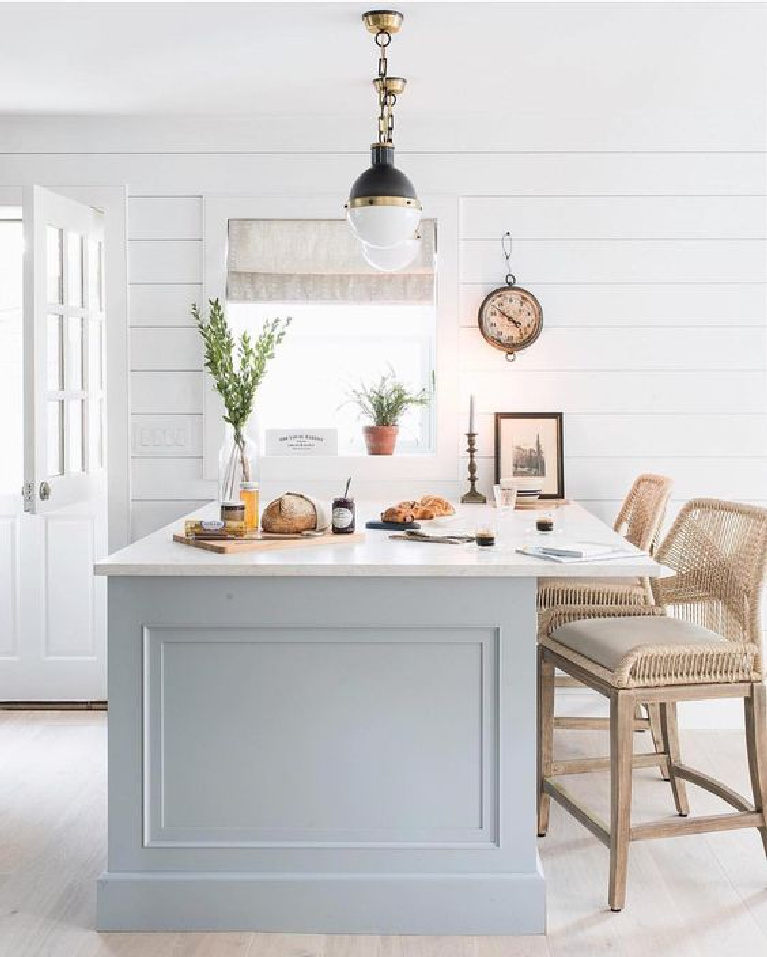 Bright Bazaar designed kitchen with grey painted island, midcentury modern pendants, and shiplap on walls. Try Behr Teton Blue for a similar look.