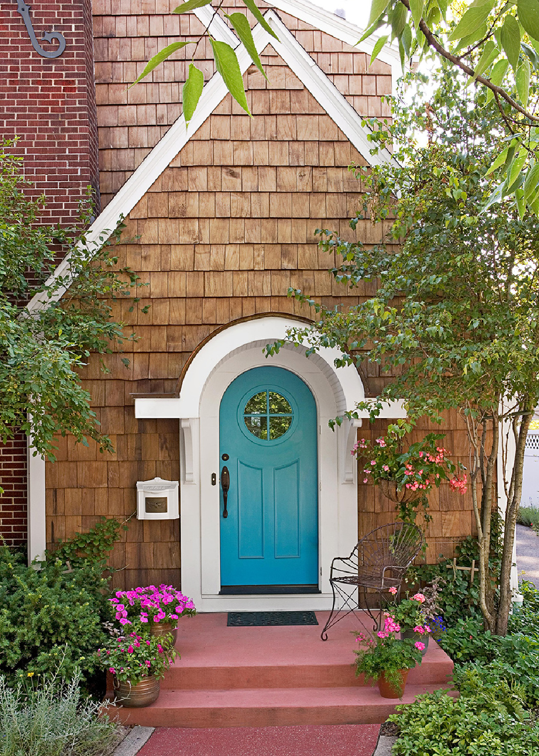 Turquoise front door with arch and round window on a cedar shake cottage - BHG (photo: Janet Mesic-Mackie). #turquoise #frontdoors #tudorcottage