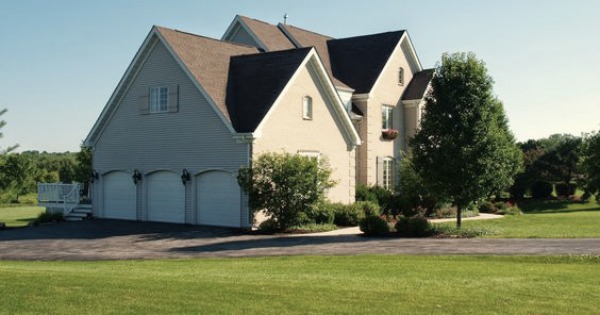 Exterior of our French country home with 3-car sideload garage. Hello Lovely Studio.