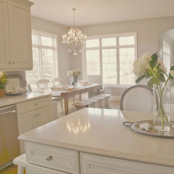 French country kitchen with creamy white cabinets, pewter hardware, and breakfast area with harvest table. Design by Hello Lovely Studio. #hellolovelystudio #frenchcountry #kitchen