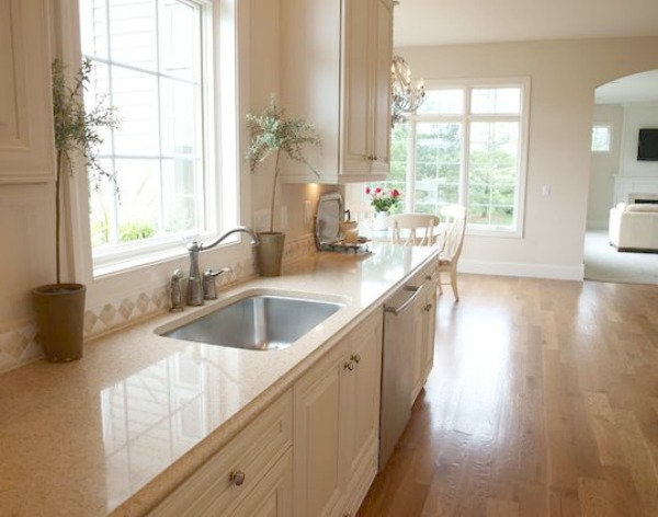 Undermount stainless sink, Silestone quartz in "Ivory Coast," and creamy white cabinets in a traditional French country kitchen with white oak hardwood flooring. Hello Lovely Studio. #hellolovelystudio #kitchen #frenchcountry #silestone #quartz #ivorycoast