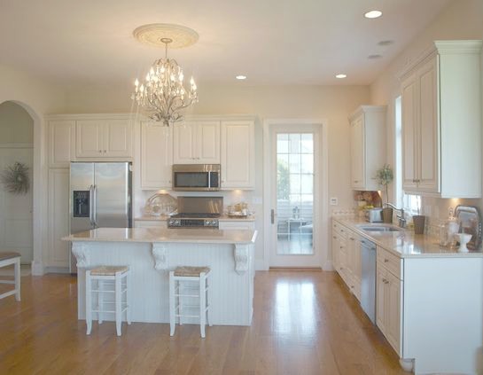 French country kitchen with antiqued silver chandelier over island and white oak floor. Hello Lovely Studio.