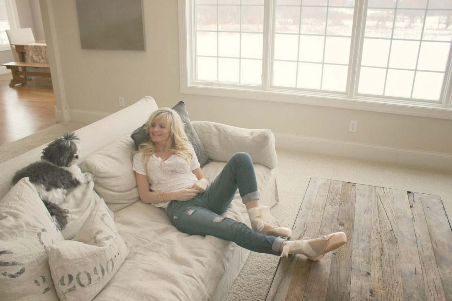 Michele of Hello Lovely Studio at home on a Belgian linen sofa. Come be inspired by Get the Look: Warm White Living Room Design With Unfussy Sophisticated Style...certainly soothing indeed.