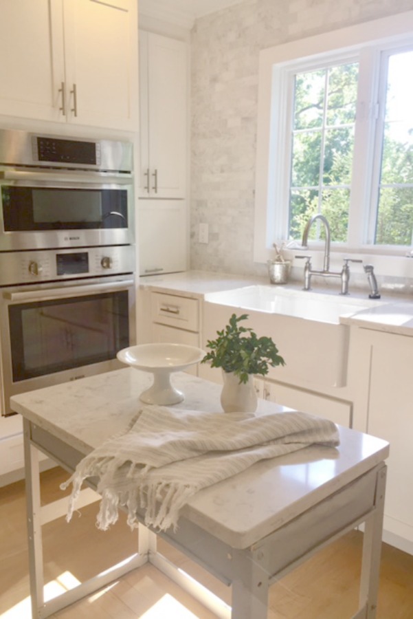 Industrial cart with quartz top in white serene kitchen by Hello Lovely. #anniesloan #parisgrey #industrialcart #worktable #kitchendesign #whitekitchen #hellolovelystudio