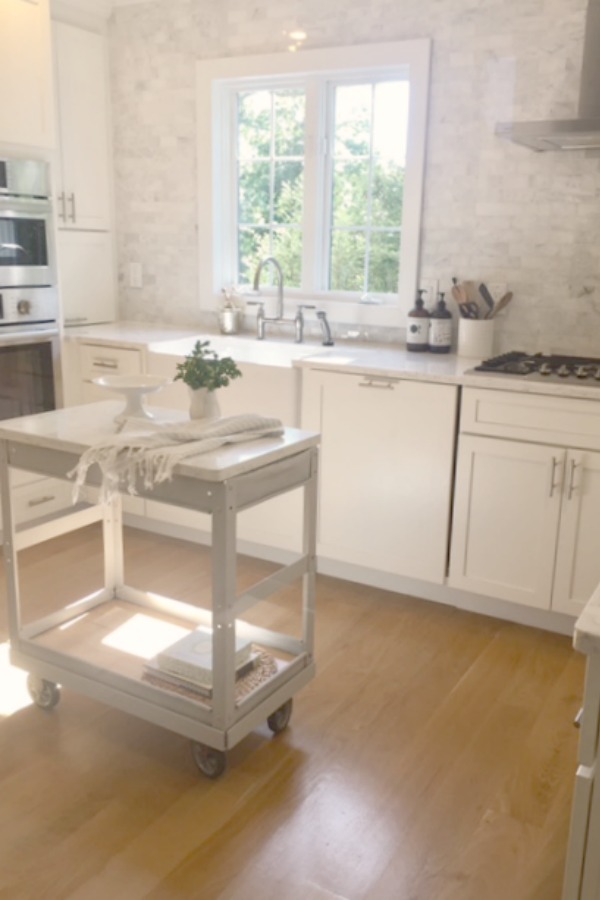 Industrial farmhouse cart in a serene white kitchen by Hello Lovely Studio. #hellolovelystudio #industrialcart #trolley #worktable