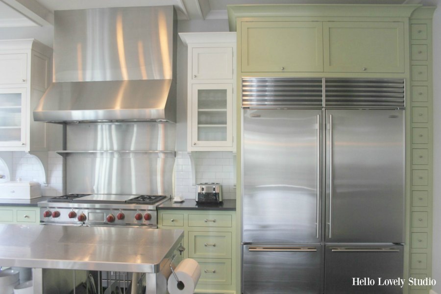 Industrial Chic Farmhouse Kitchen Inspiration with green cabinets, custom stainless island, and black stained flooring. #modernfarmhouse #kitchendesign #industrialfarmhouse #farmhousekitchen #benjaminmoorestoningtongray