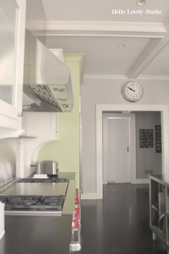 Industrial Chic Farmhouse Kitchen Inspiration with green cabinets, custom stainless island, and black stained flooring. #modernfarmhouse #kitchendesign #industrialfarmhouse #farmhousekitchen #benjaminmoorestoningtongray