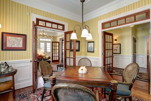 Before & After: Fussy Traditional to Urban Chic. Yellow stripe wallpaper, wainscot paneling, and wood furniture in French country decorated home.