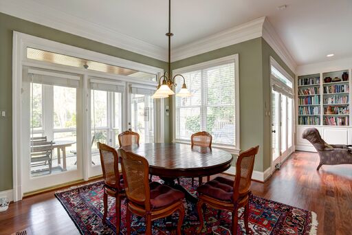 Traditional style breakfast room with sage green walls and red accents.