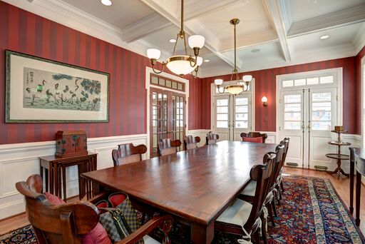 Red stripe wallpaper and decorative mouldings in French country dining room.