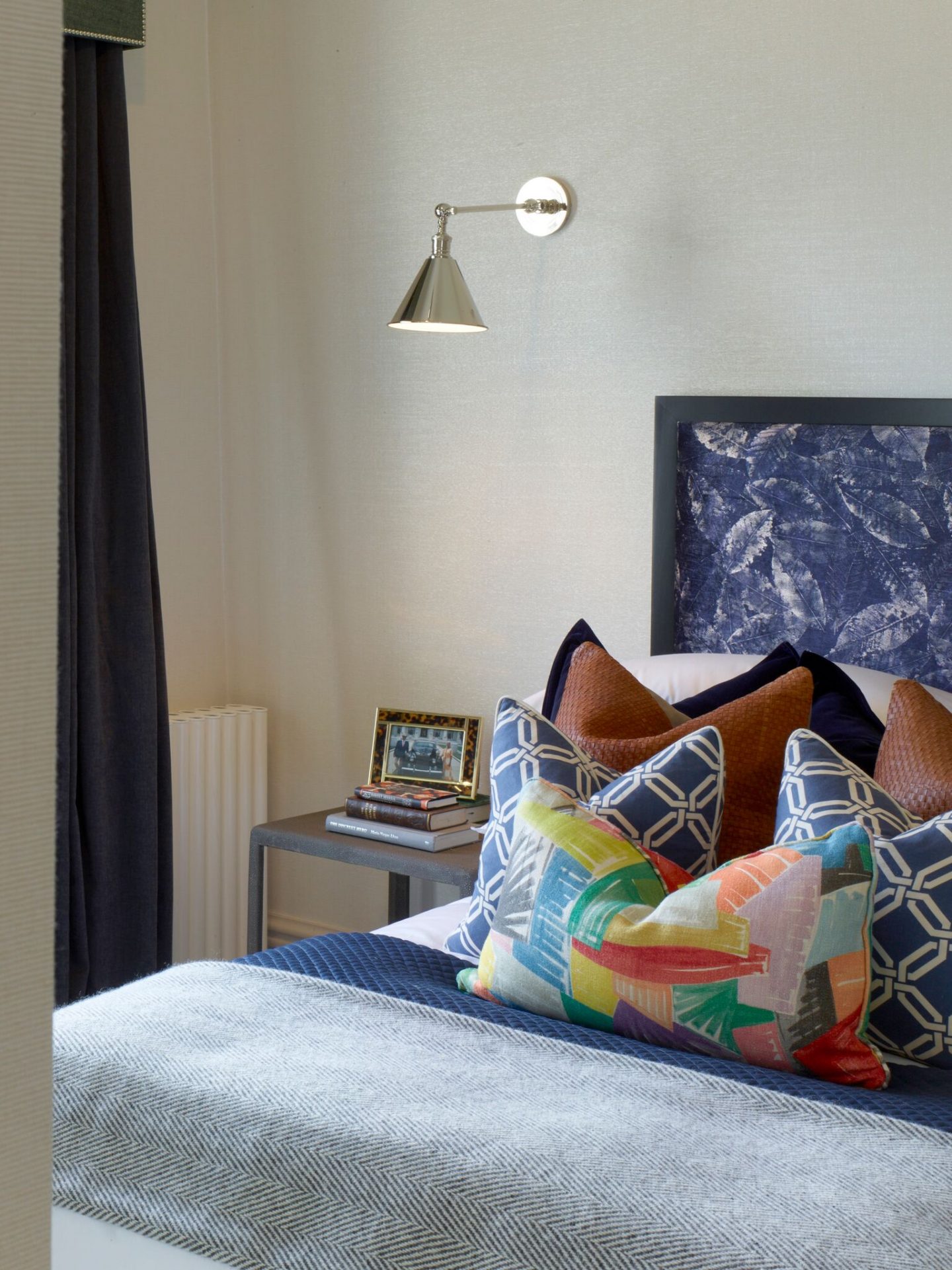 Modern wall sconce and blue upholstered headboard in London apartment. Colorful Classic Decor in London Inspired by 'Out of Africa' - come see more from Studio L London! #britishcolornial #livingroom #pinkandgreen #elegantdecor #Londonapartment #interiordesigninspiration