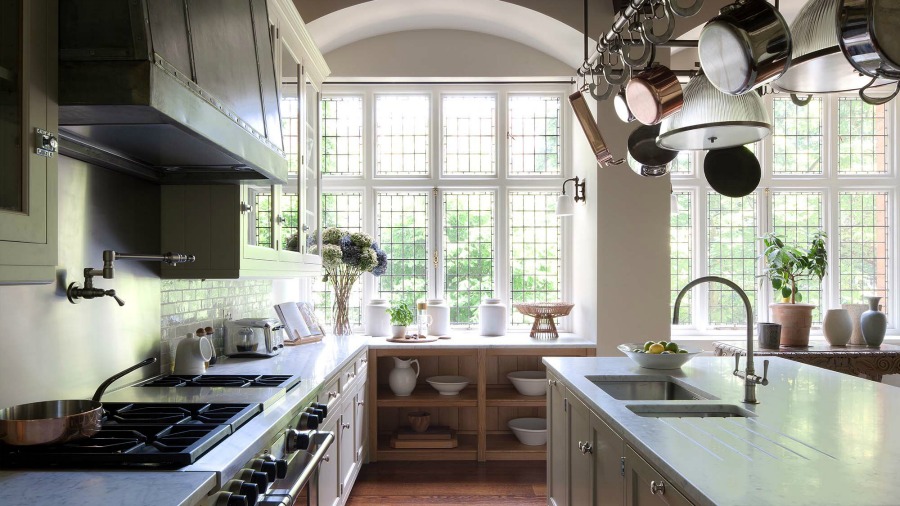 New England style coastal kitchen design by Artichoke and Michael Smith. The pot rack above the island resolved a lighting issue. #bespoke #kitchendesign #artichoke #coastalkitchen #newengland