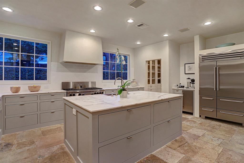 Minimal luxe kitchen. Luxurious interior design details in a Tudor Revival house renovation in Houston. Design consultant: Pam Pierce. Many reclaimed antique materials from Chateau Domingue. #housetour #oldworld #pampierce #chateaudomingue #europeanantiques #luxurioushome #interiordesignideas #Frenchcountry #limestone #reclaimedflooring #bespoke #houstonhome