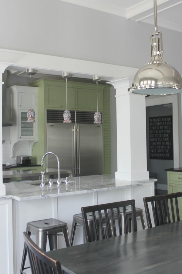 Industrial Chic Farmhouse Kitchen Inspiration with green cabinets, custom stainless island, and black stained flooring. #modernfarmhouse #kitchendesign #industrialfarmhouse #farmhousekitchen #benjaminmoorestoningtongray
