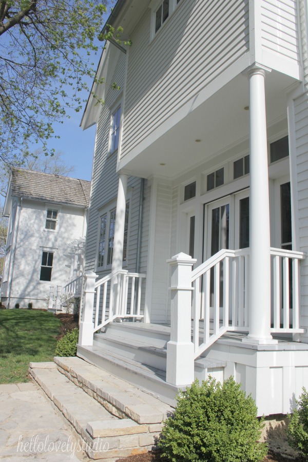 White modern farmhouse exterior with cedar siding, board and batten, metal galvalume roof, and black trim accents. Come see more! Photo by Hello Lovely Studio. #modernfarmhouse #exterior #whitefarmhouse #boardandbatten #housedesign #farmhousearchitecture #hellolovelystudio