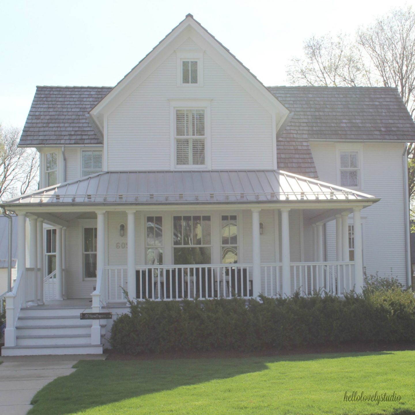 Charming white exterior of 1875 Industrial modern farmhouse with cedar siding, board and batten, metal galvalume roof, and black trim accents. Come see more! Photo by Hello Lovely Studio. 