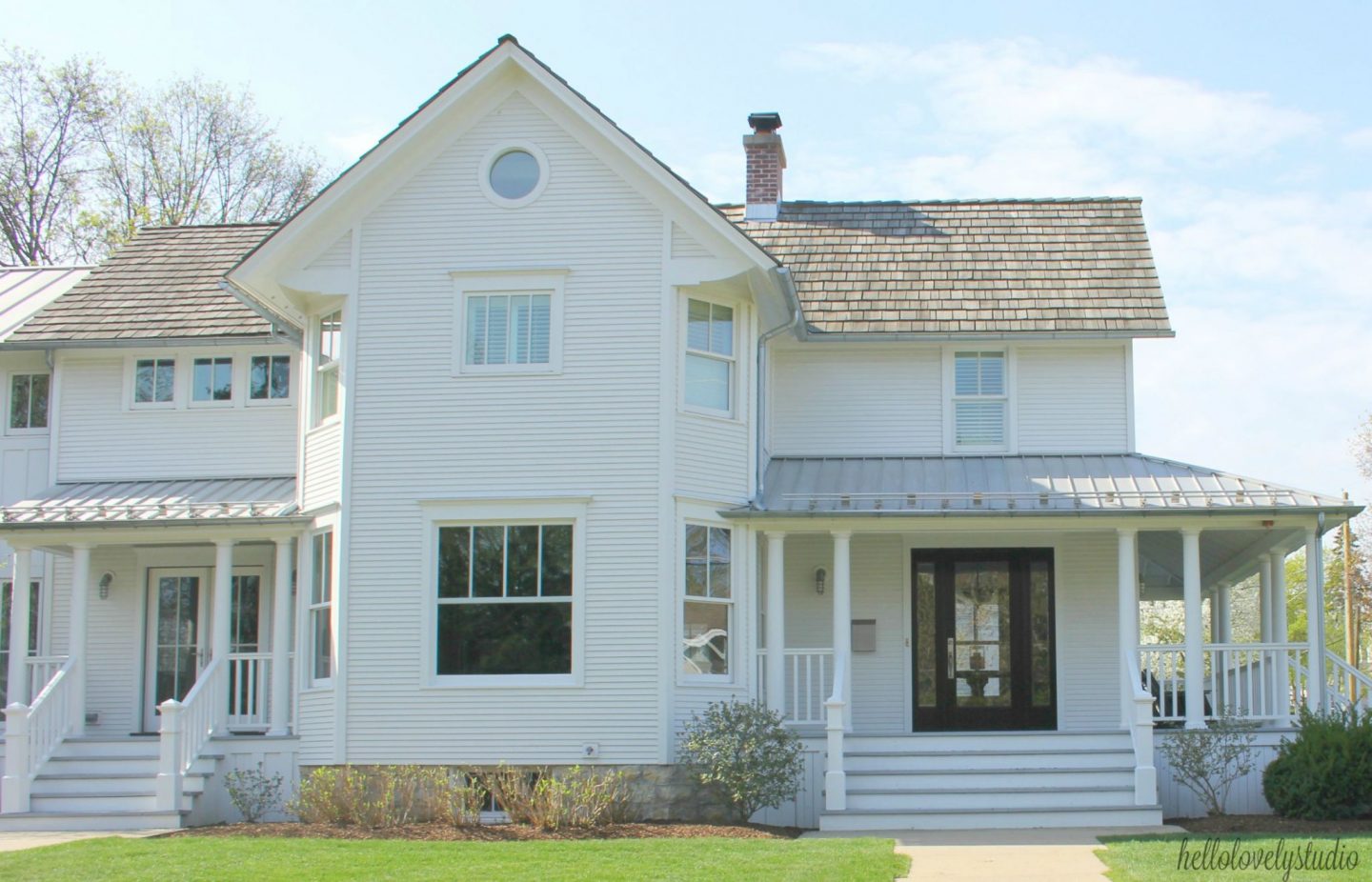 White farmhouse exterior with two porches and board and batten detailing. #hellolovelystudio #modernfarmhouse #houseexterior #farmhousearchitecture #whitefarmhouse