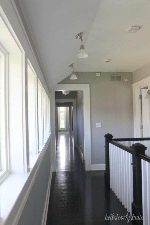 Black floors, medium grey paint colors, and white trim in a renovated modern farmhouse with industrial interiors. #interiordesign #blackfloors #industrialfarmhouse #greypaint