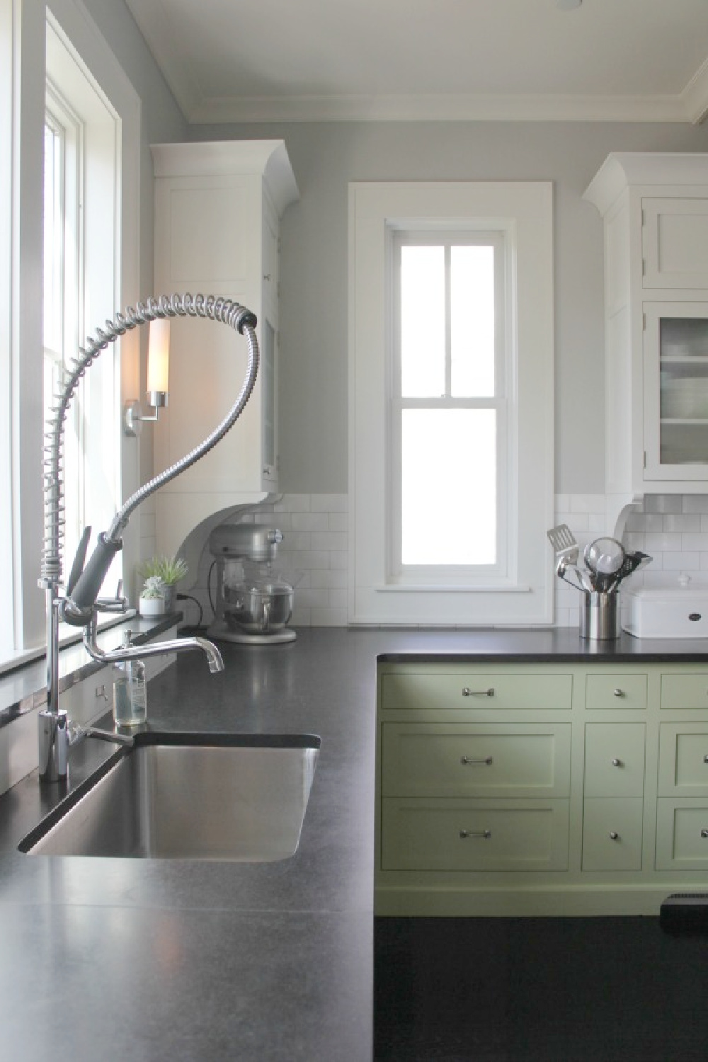 Modern farmhouse kitchen with soapstone counters, stainless steel appliances, spring green cabinets, and subway tile. #modernfarmhousekitchen #industrialfarmhouse #benjaminmoorestoningtongray