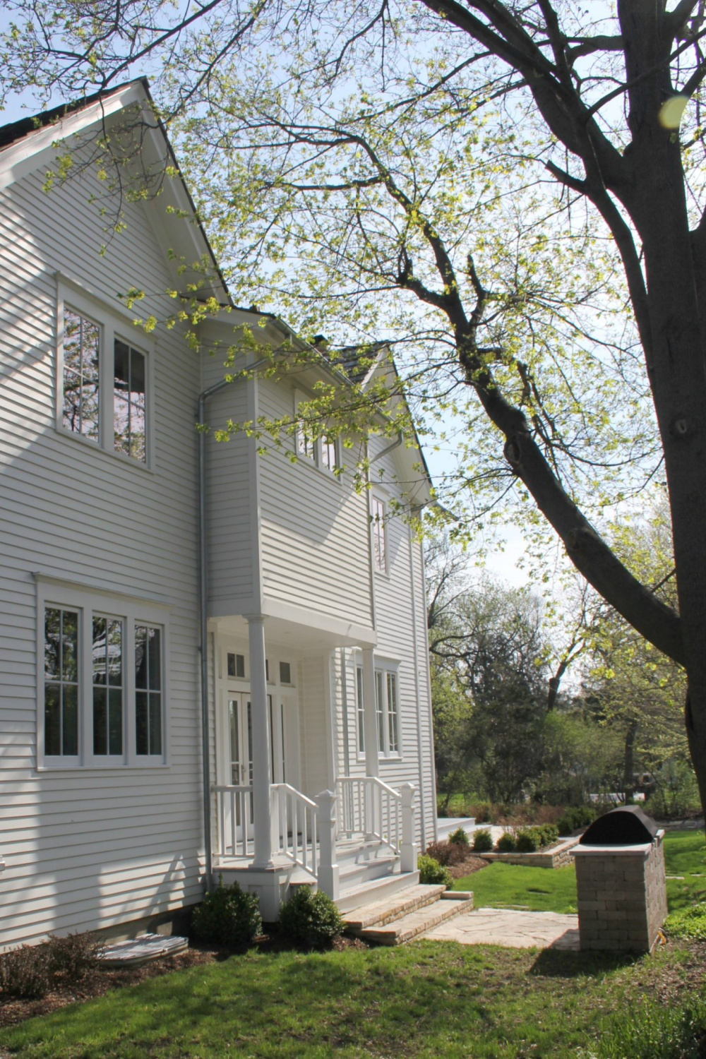 White modern farmhouse exterior with cedar siding, board and batten, metal galvalume roof, and black trim accents. Come see more! Photo by Hello Lovely Studio. #modernfarmhouse #exterior #whitefarmhouse #boardandbatten #housedesign #farmhousearchitecture #hellolovelystudio