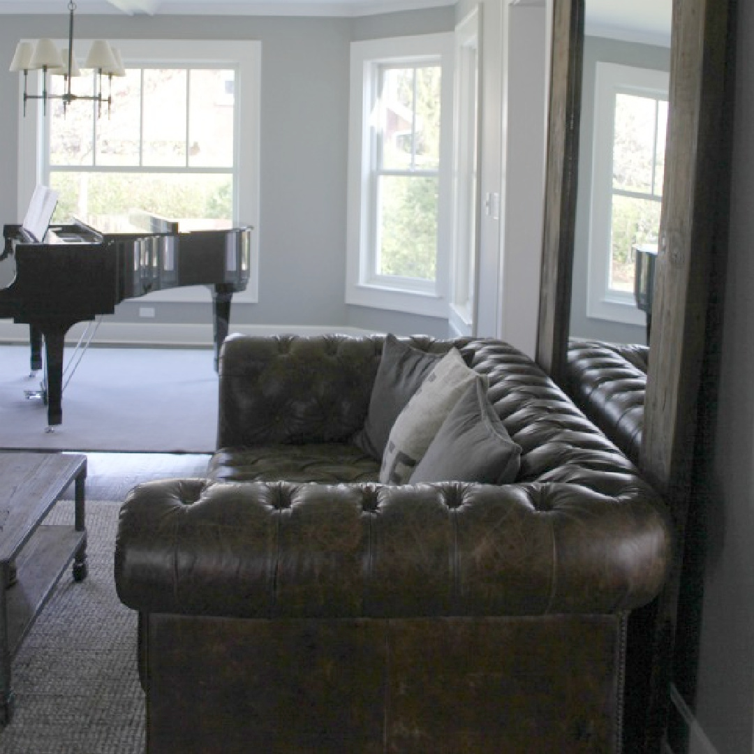 Stonington Gray paint color on walls in a living room tufted leather sofa and Grand piano - Hello Lovely Studio.