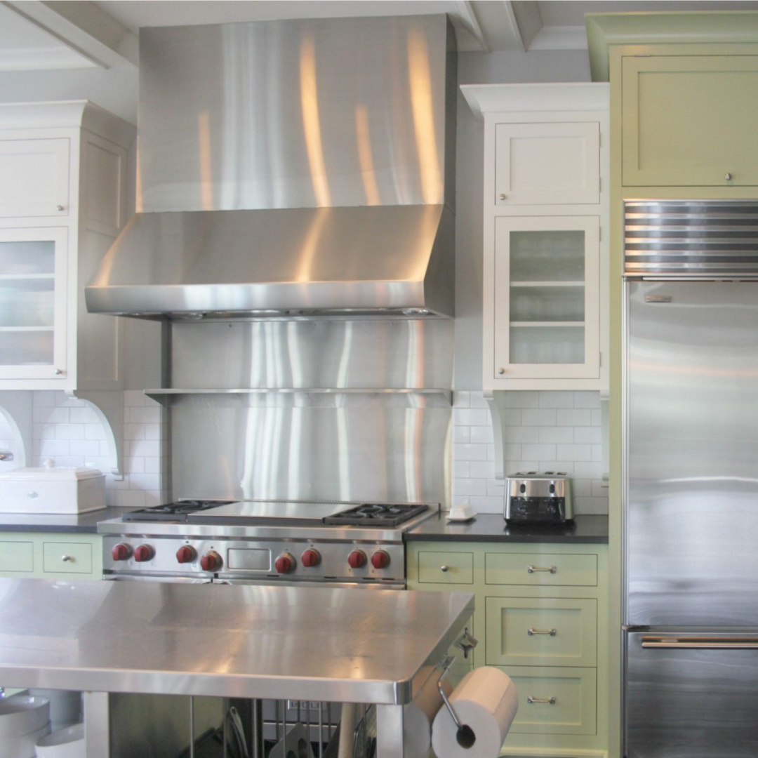 Industrial design elements in a modern farmhouse kitchen with stainless work table - Hello Lovely Studio. #greenkitchen #farmhousekitchen