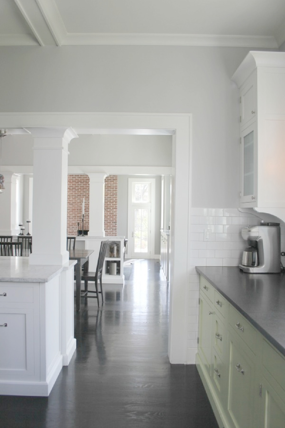 Farmhouse kitchen with two tone cabinets (green and white), soapstone countertops, and black stained hardwood floors - Hello Lovely Studio.