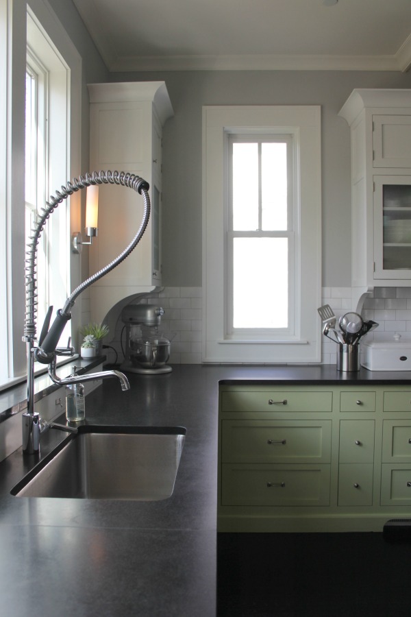 Custom green base cabinets in a charming farmhouse kitchen with medium grey paint colors. Farmhouse interior design inspiration for fans of industrial, modern, and traditional farmhouse house designs.  #interiordesign #indusrialfarmhouse #kitchen #paintcolor