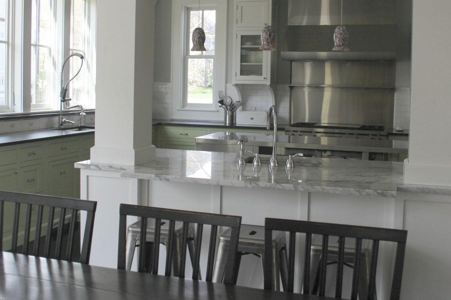 Industrial Chic Farmhouse Kitchen Inspiration with green cabinets, custom stainless island, and black stained flooring. #modernfarmhouse #kitchendesign #industrialfarmhouse #farmhousekitchen #benjaminmoorestoningtongray