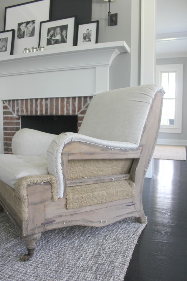 A deconstructed arm chair in a living room. Farmhouse interior design inspiration for fans of industrial, modern, and traditional farmhouse house designs. This 1875 historical farmhouse in Barrington, Illinois was renovated to a high standard with superior craftsmanship and bespoke design details. Score medium grey paint colors and ideas for decorating. #industrialfarmhouse #greypaint