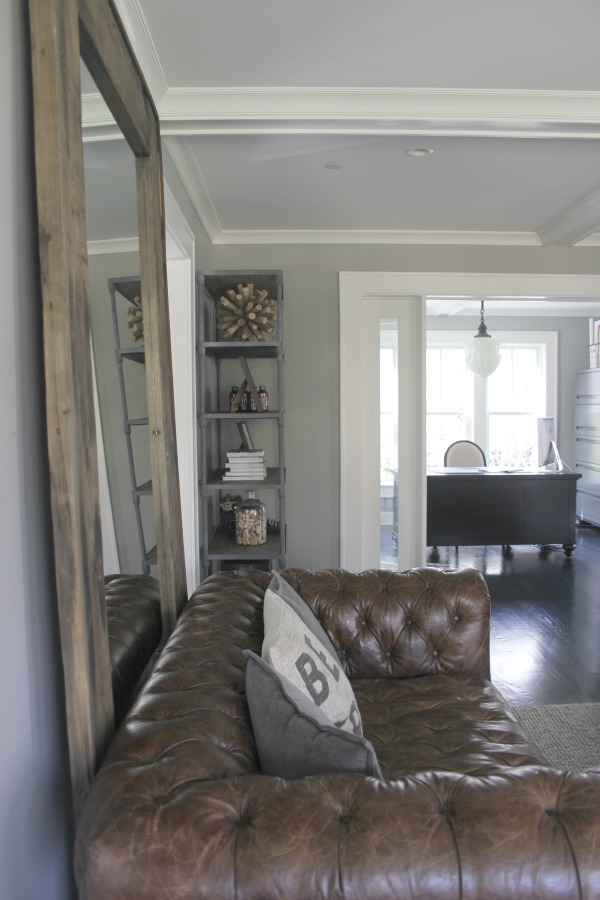 Chesterfield sofa in a neutral living room with a mix of vintage and modern. Farmhouse interior design inspiration for fans of industrial, modern, and traditional farmhouse house designs. This 1875 historical farmhouse in Barrington, Illinois was renovated to a high standard with superior craftsmanship and bespoke design details. Come learn the medium grey paint colors used here! #greypaintcolor #interiordesign #livingroom #chesterfieldsofa